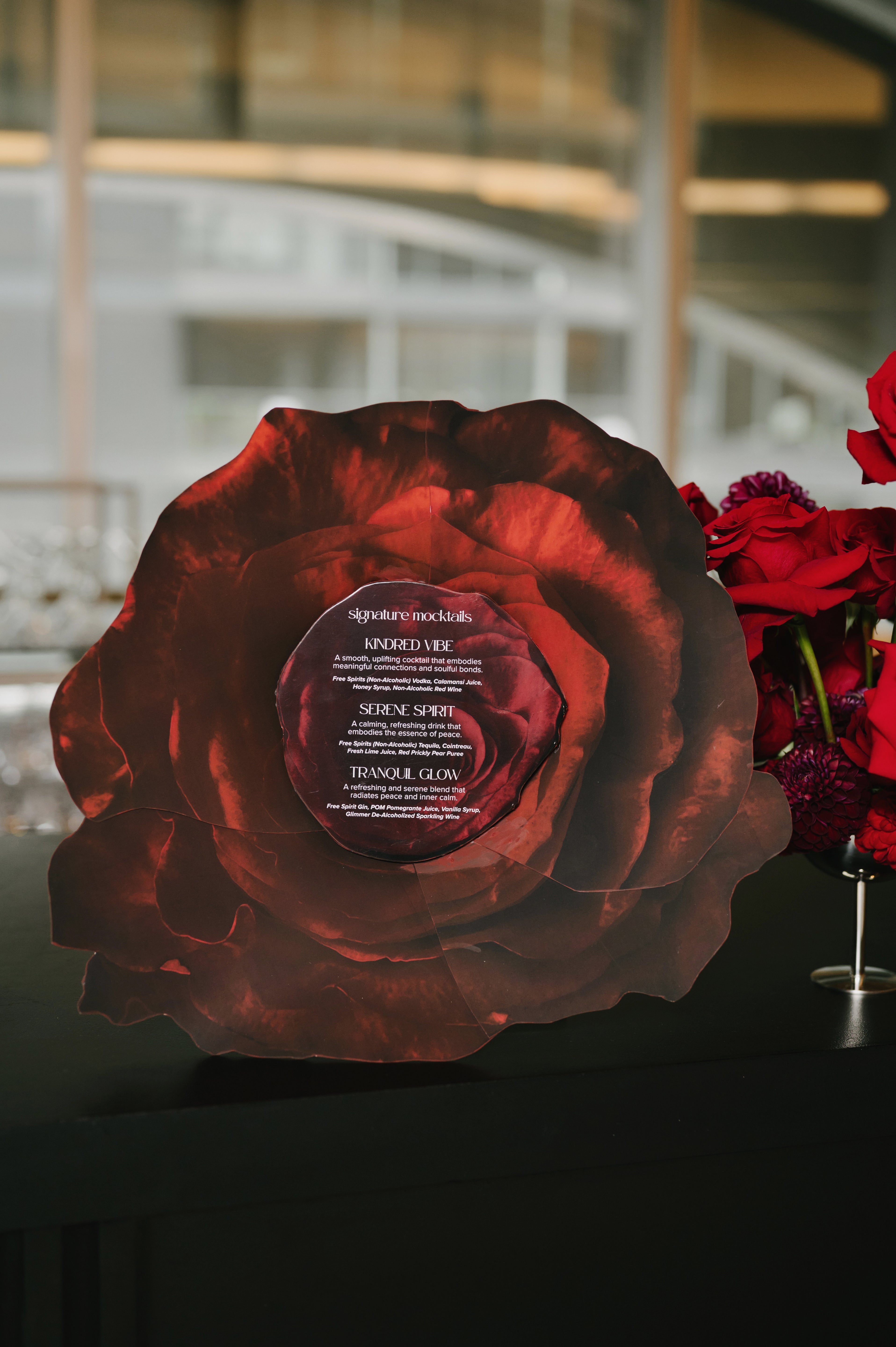 A bespoke, custom-shaped bar sign in the silhouette of a rose. This die-cut floral signage features elegant typography, showcasing Heirloom Stationery's ability to create unique, non-traditional event branding.